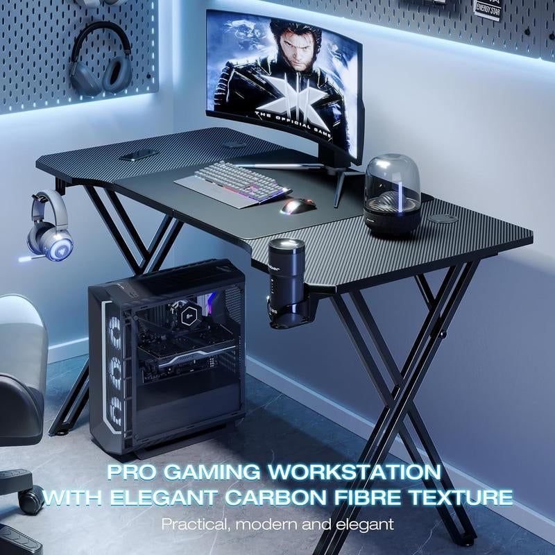 Gaming workstation with carbon fiber texture desk, monitor, keyboard, and gaming chair.
