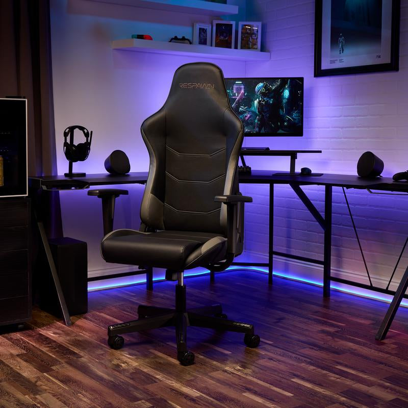Gaming chair in a room with purple lighting, desk, and computer setup.